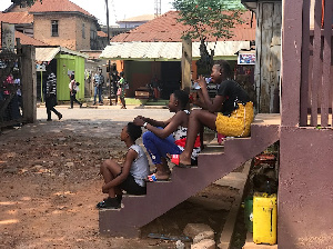 Melphia (left) sitting on the steps of Martin Opoku Sekyere’s office